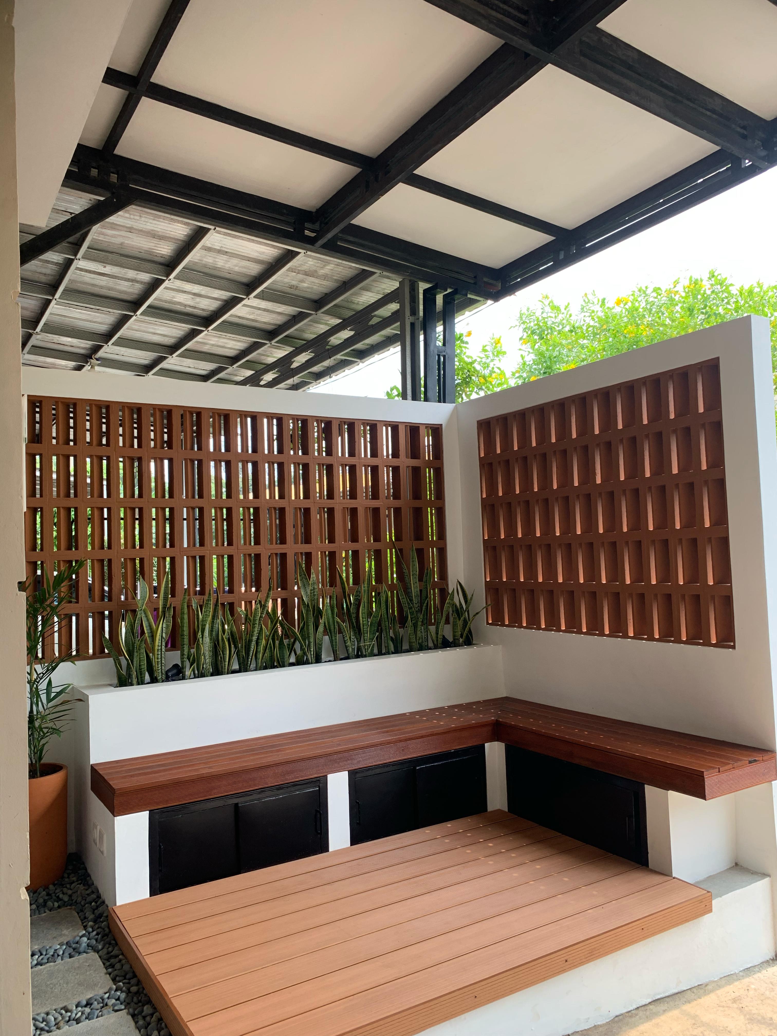 Teras outdoor dengan taman hijau yang rindang dan kursi santai